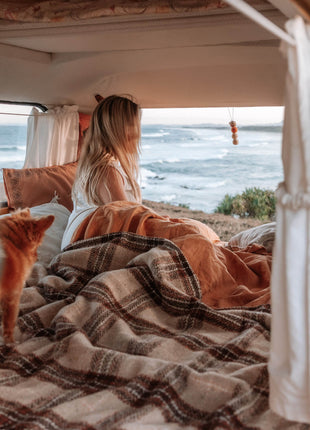 A woman and her dog in a van, with the mesmerizing ocean view behind them.