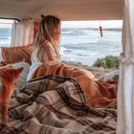 A woman and her dog in a van, with the mesmerizing ocean view behind them.